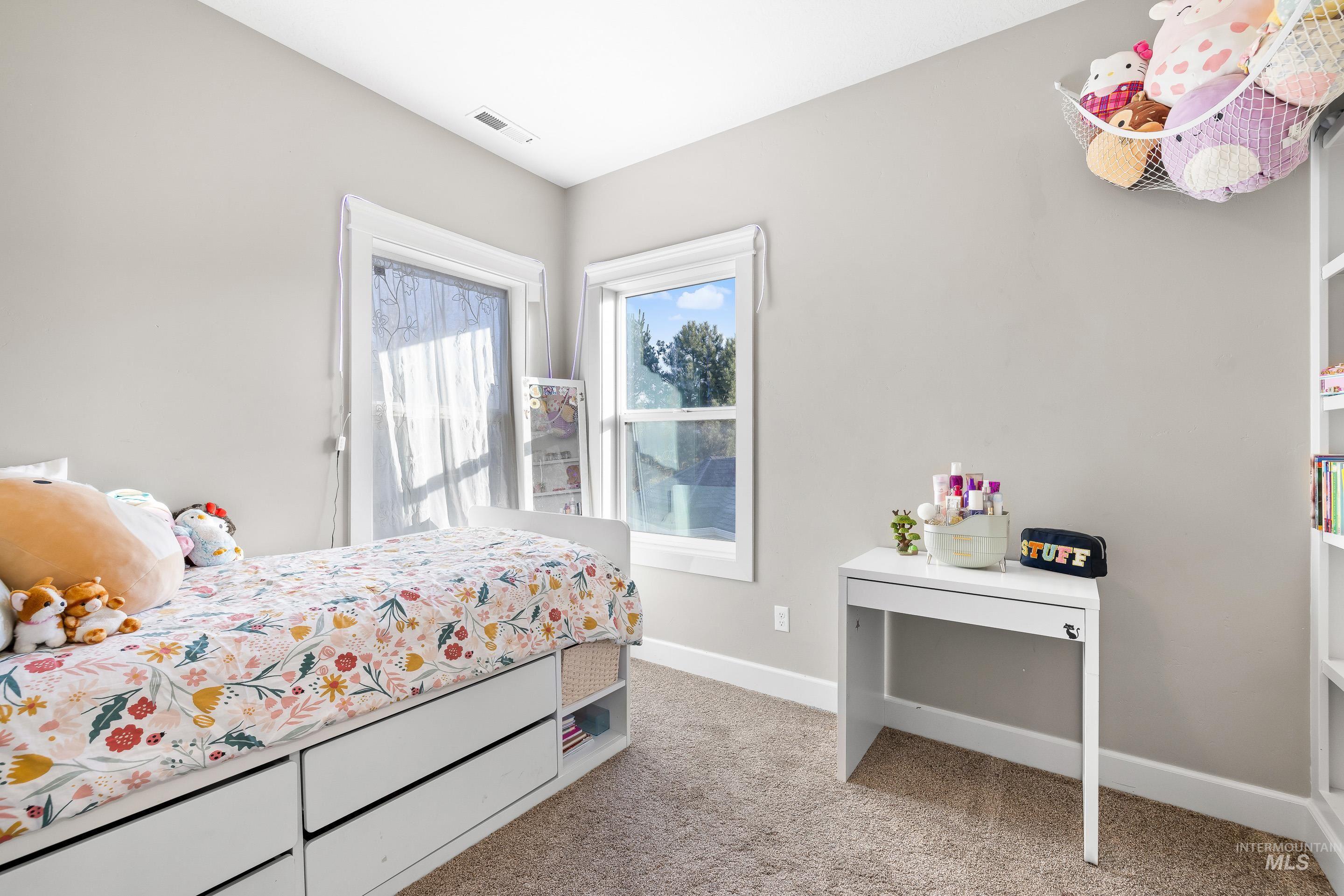 Bedroom featuring baseboards and light carpet