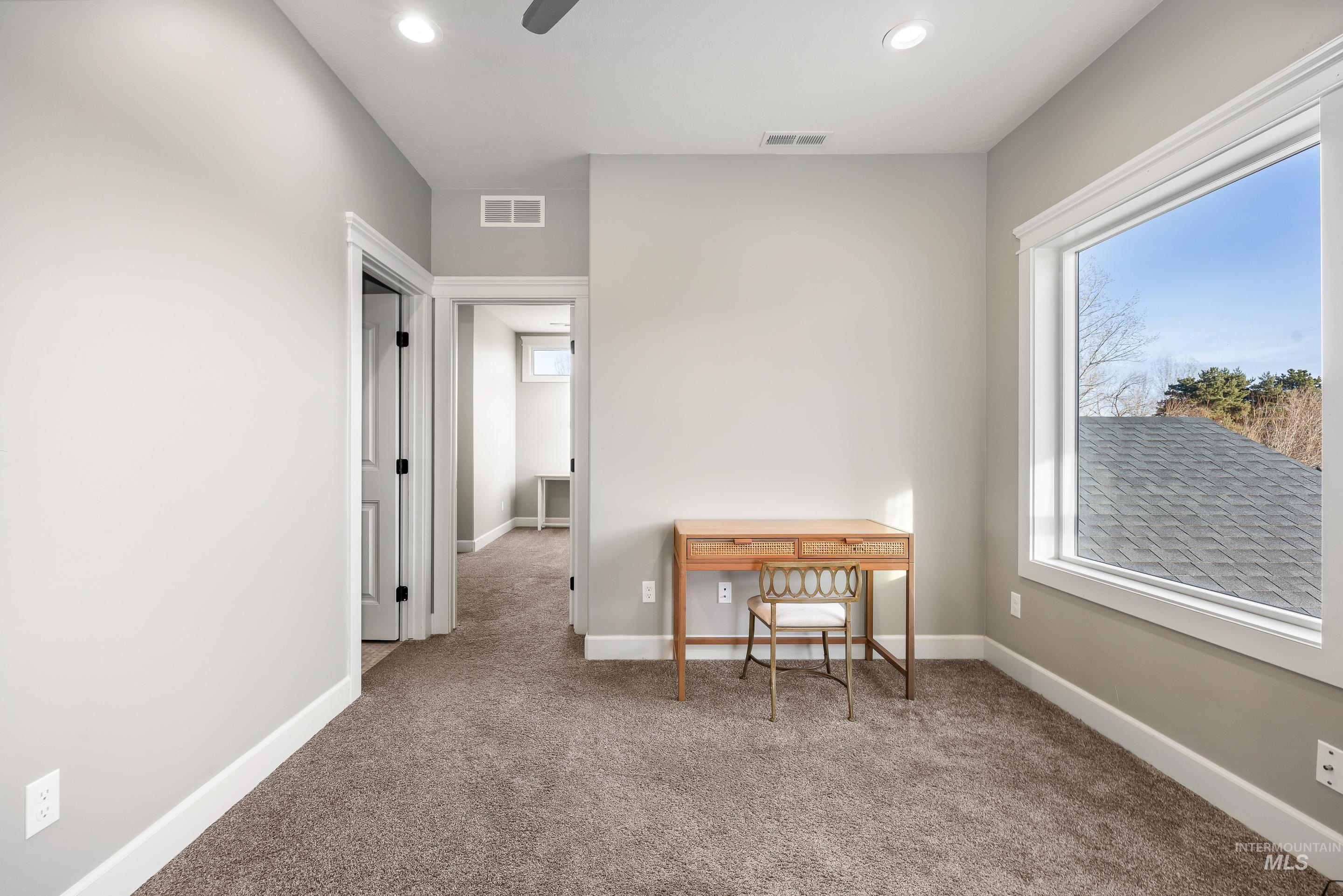 Office space featuring light colored carpet, healthy amount of natural light, ceiling fan, and recessed lighting