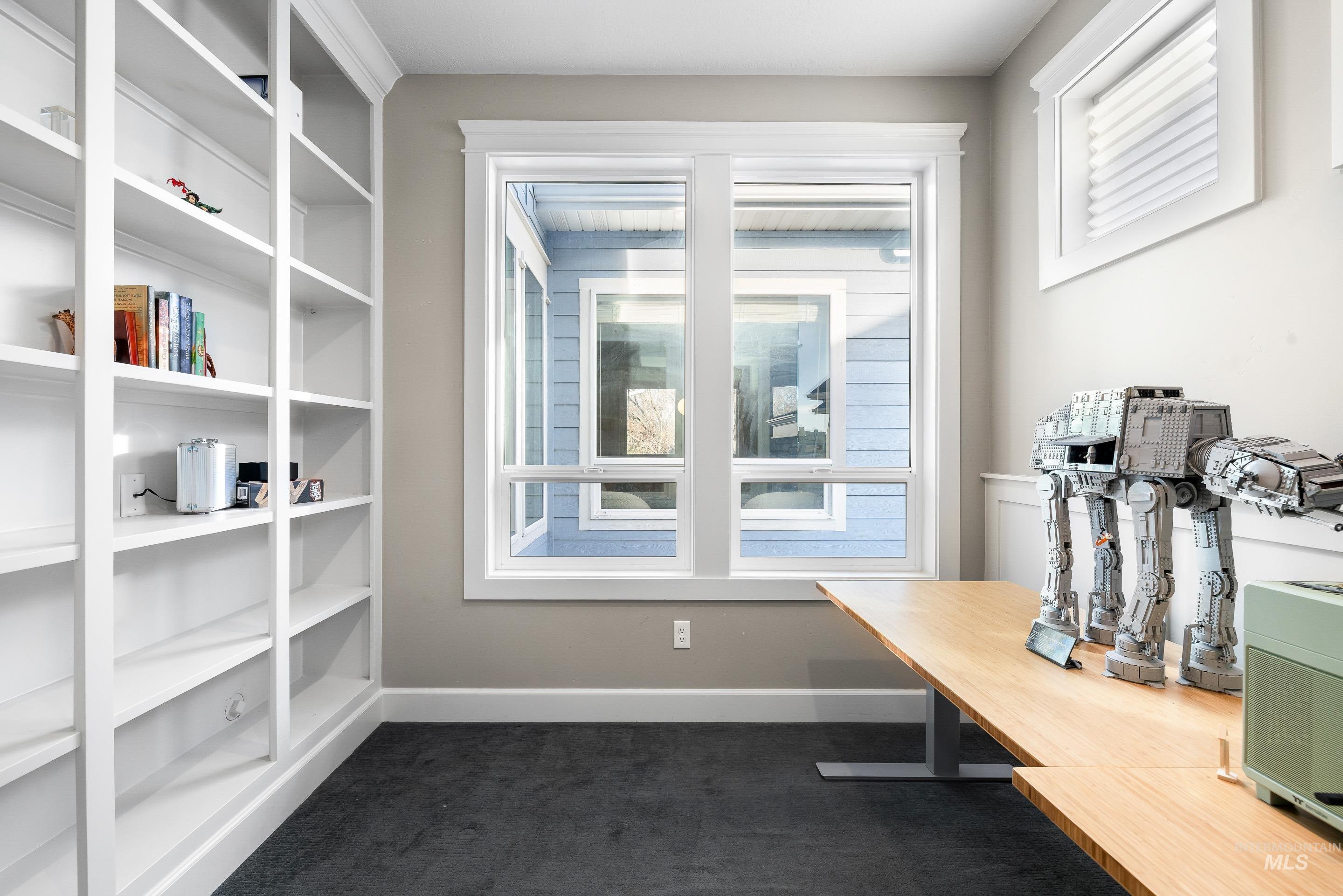 Office with healthy amount of natural light and dark carpet