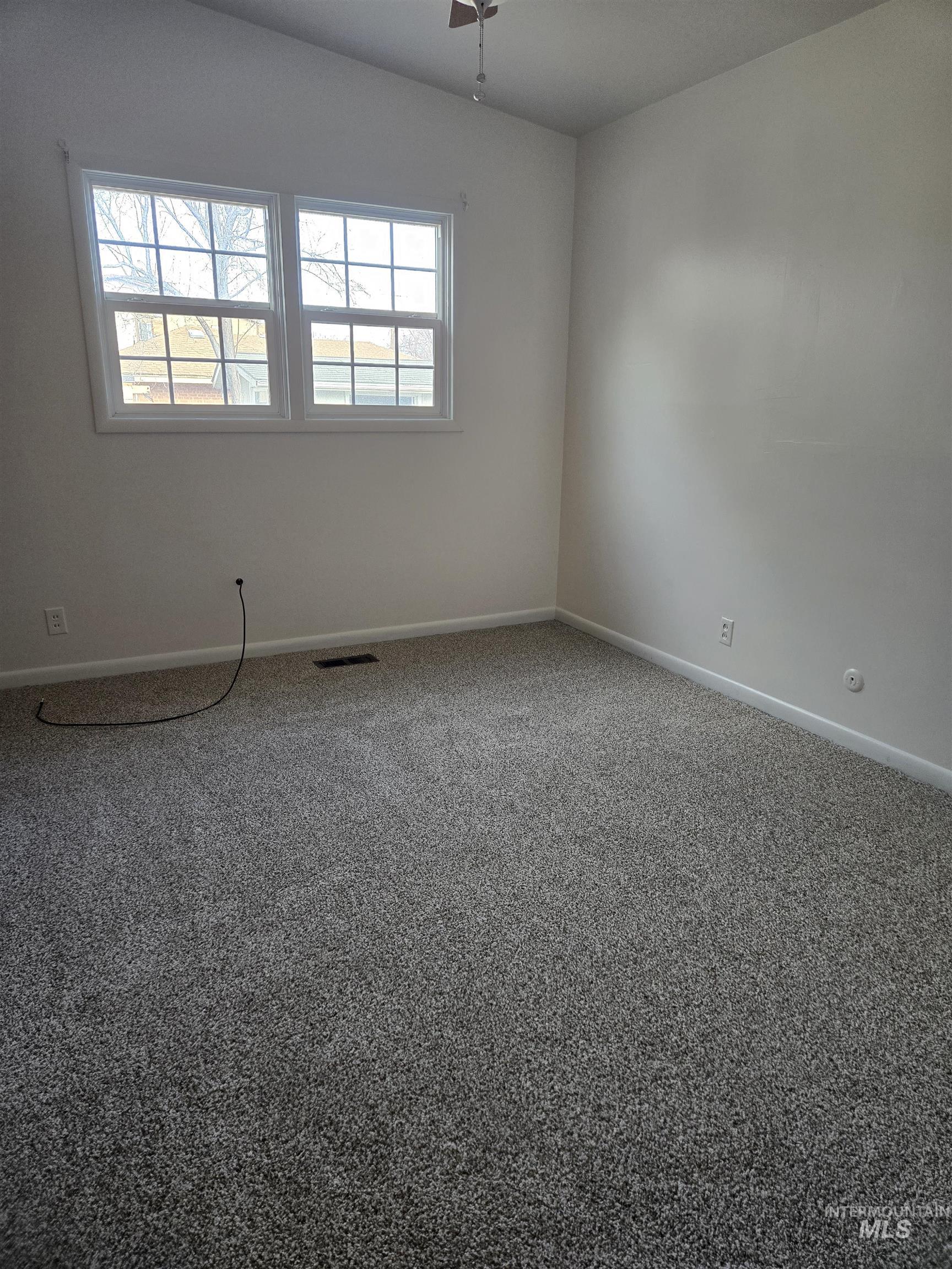 Carpeted spare room with baseboards
