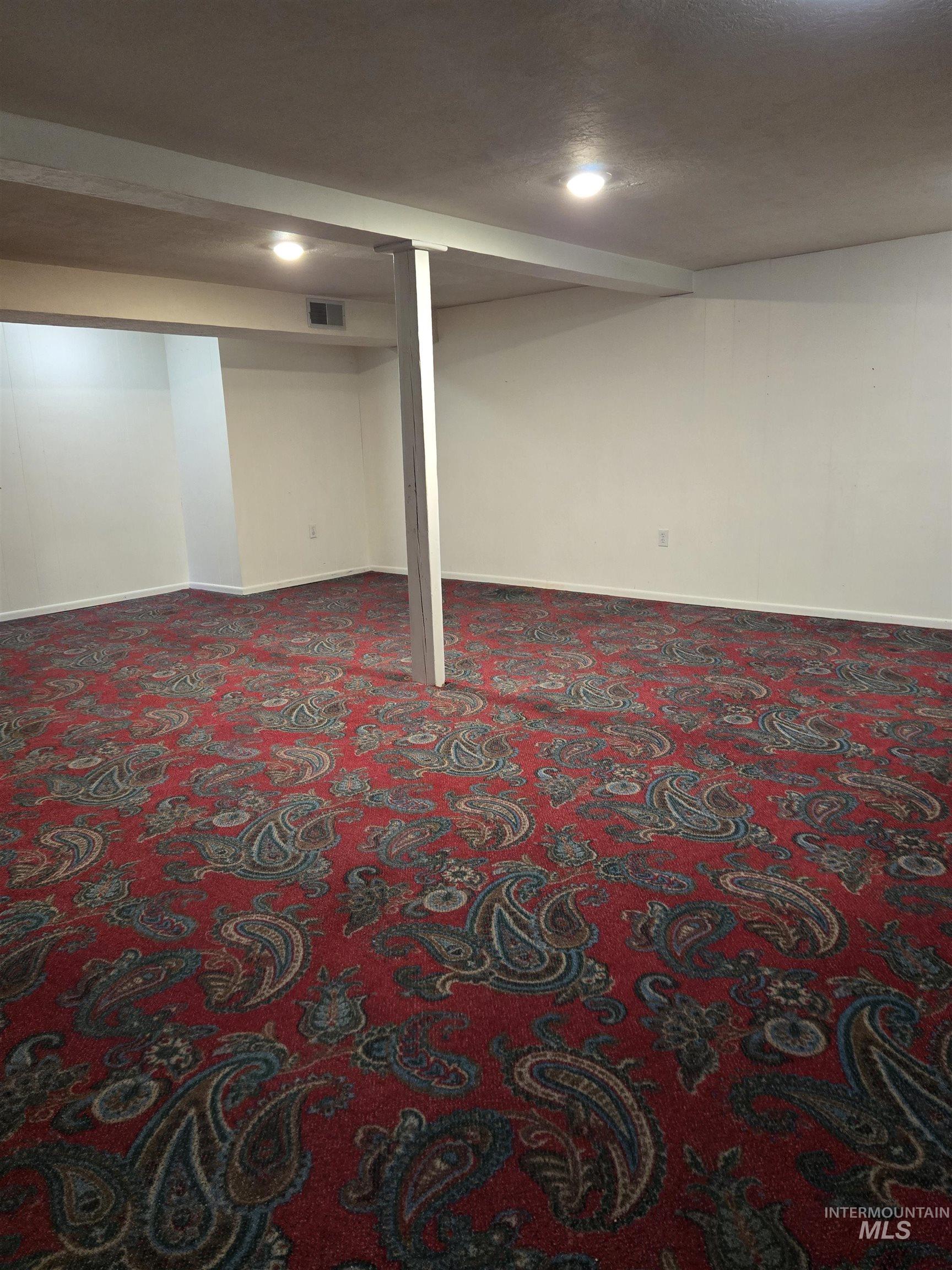 Finished basement with a textured ceiling and carpet