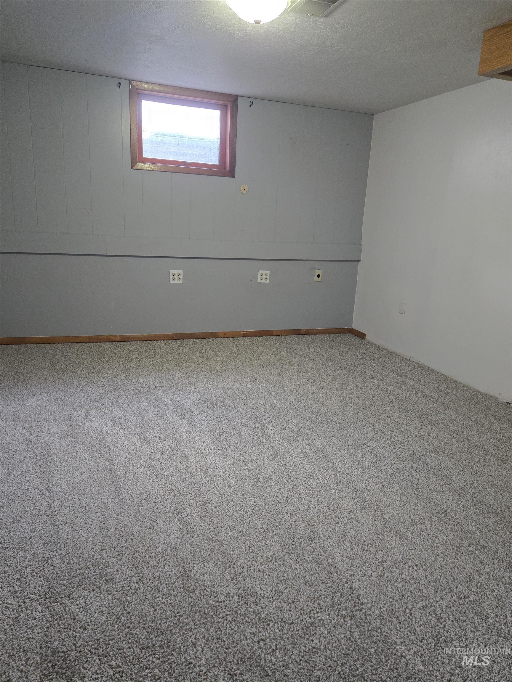 Below grade area with a textured ceiling and carpet flooring