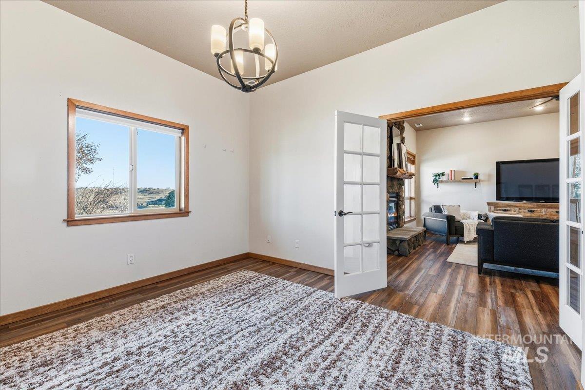 Unfurnished office with french doors, a chandelier, and dark wood finished floors