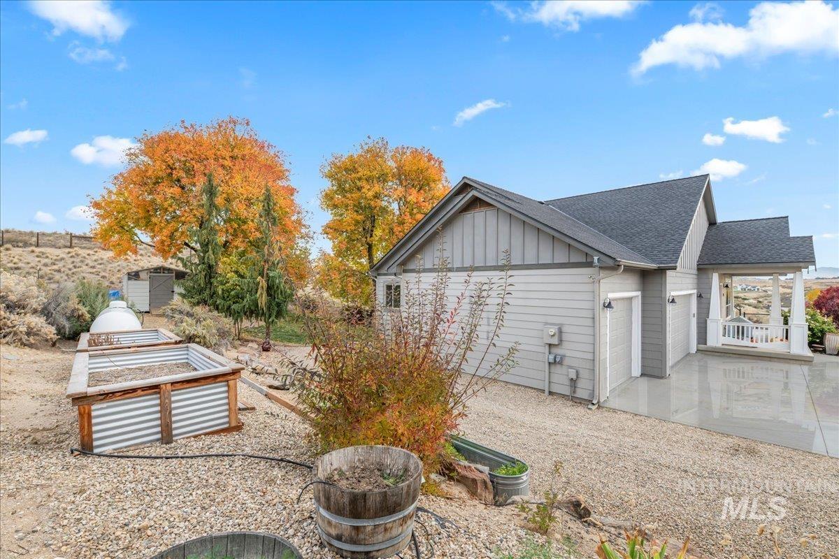 View of home's exterior featuring board and batten siding, a garage, and roof with shingles