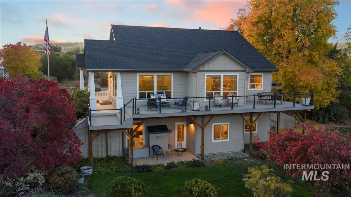 Back of property featuring a patio area, roof with shingles, and board and batten siding