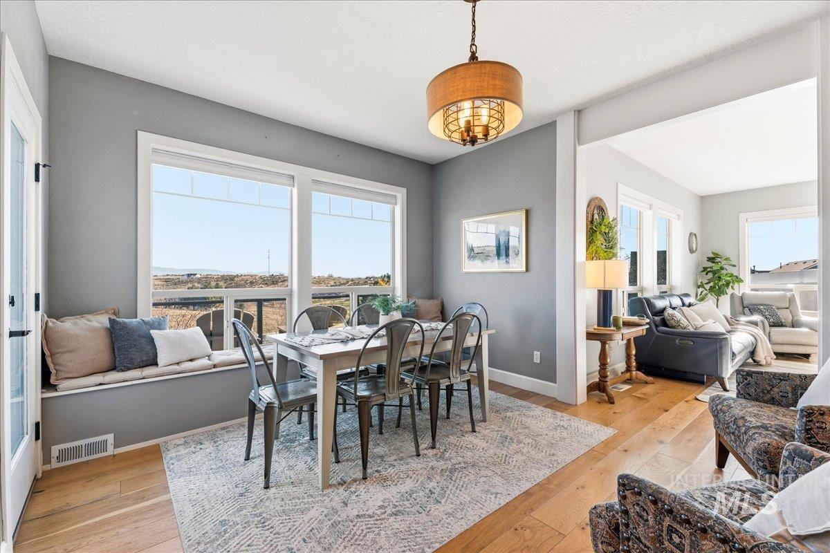 Dining area with light wood finished floors, plenty of natural light, and french doors