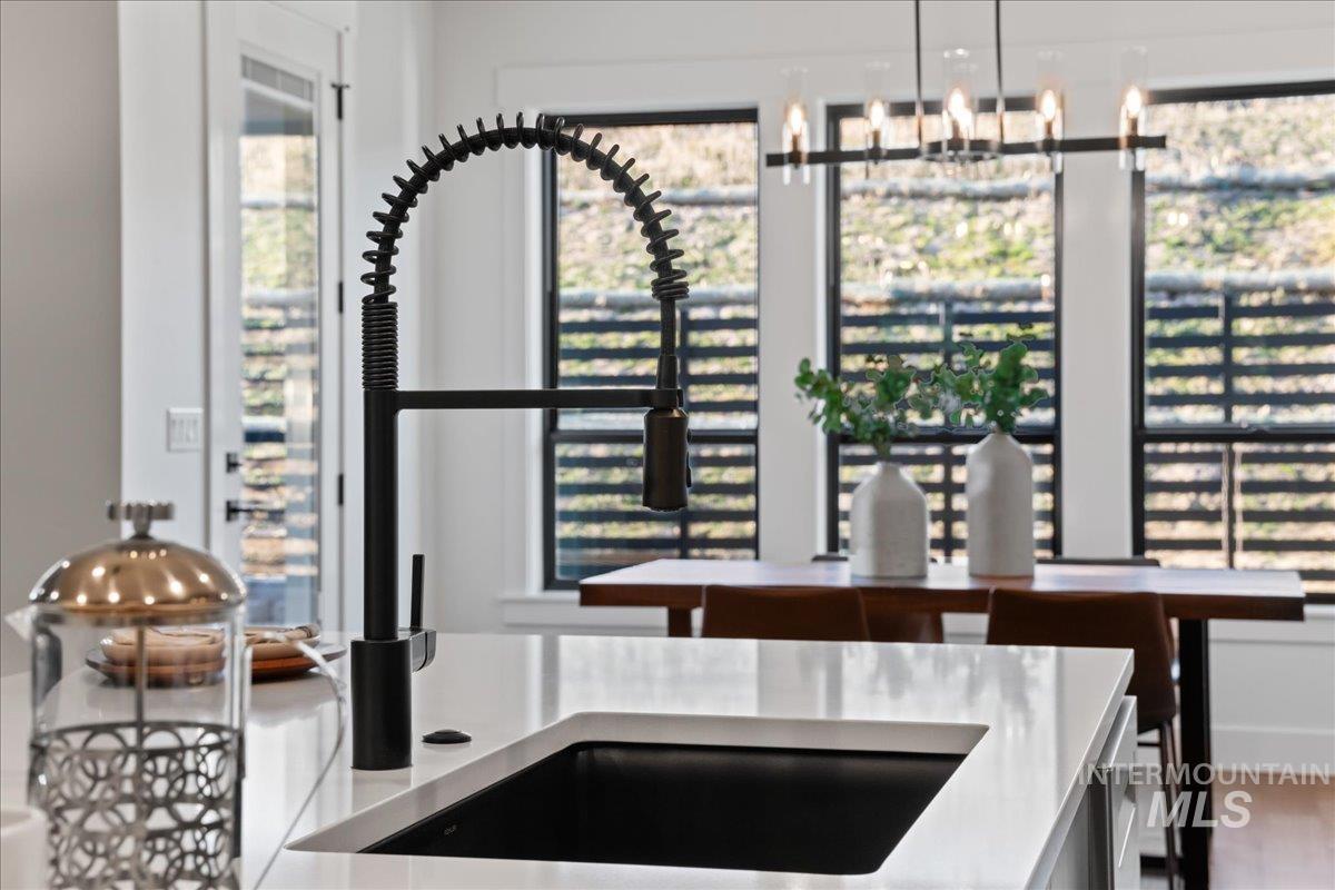 Kitchen featuring light stone countertops, a chandelier, and hanging light fixtures