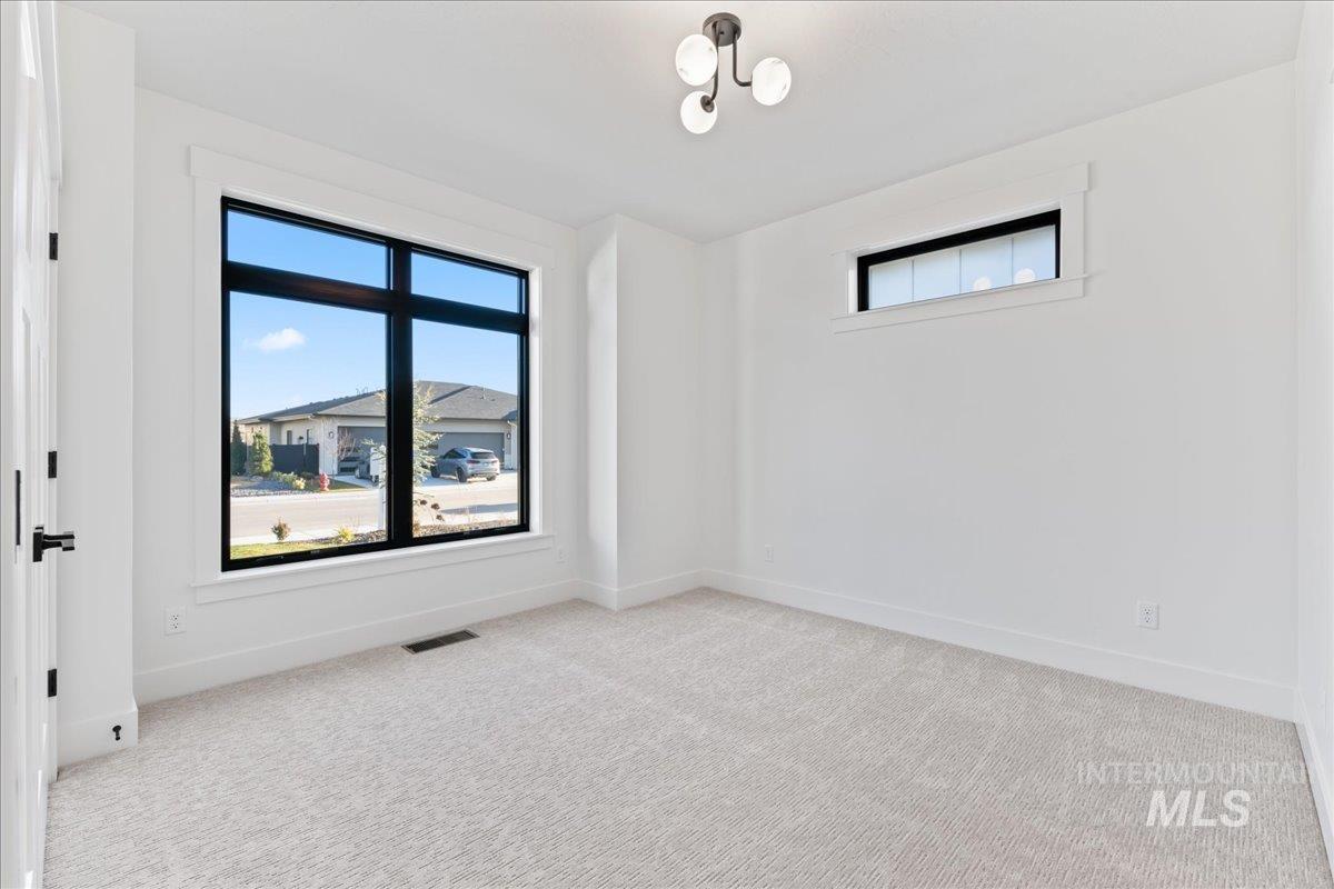 Spare room featuring plenty of natural light and light colored carpet