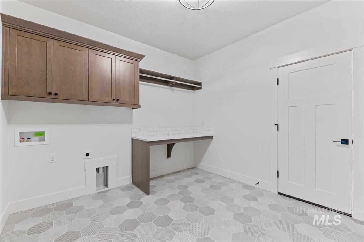 Washroom with light floors, hookup for an electric dryer, and washer hookup