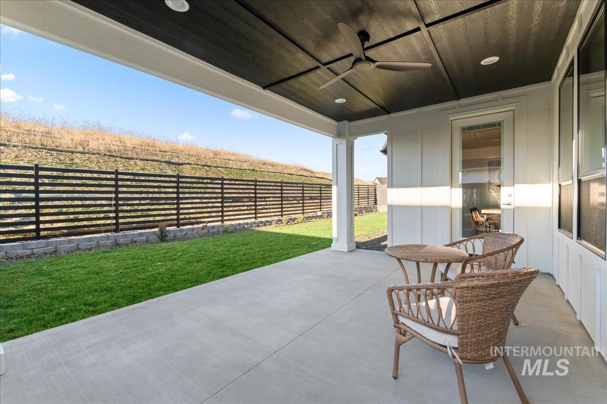 Fenced backyard with a ceiling fan and a patio