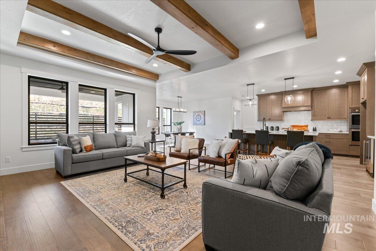 Living area featuring recessed lighting, beam ceiling, light wood-style floors, and ceiling fan