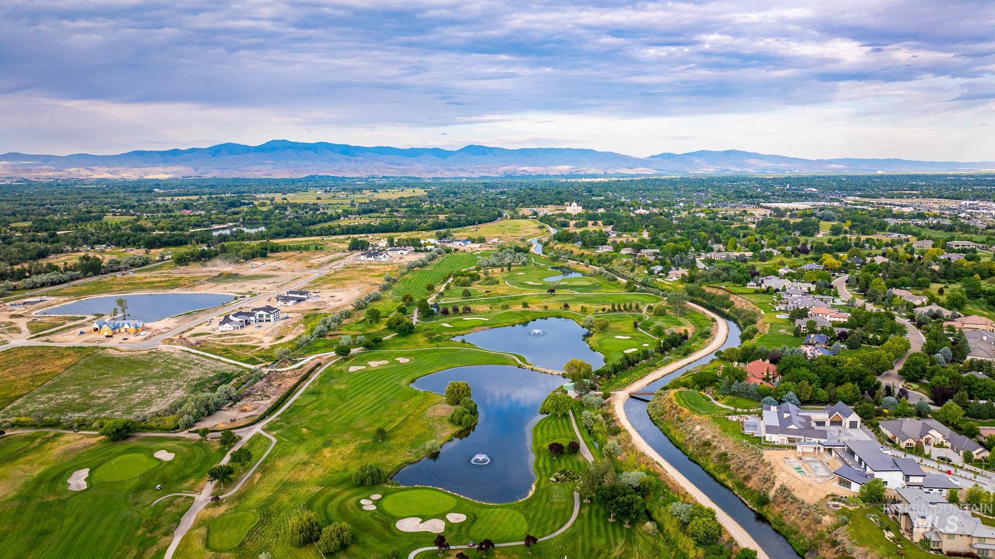 Aerial view of property's location featuring a water and mountain view and nearby suburban area