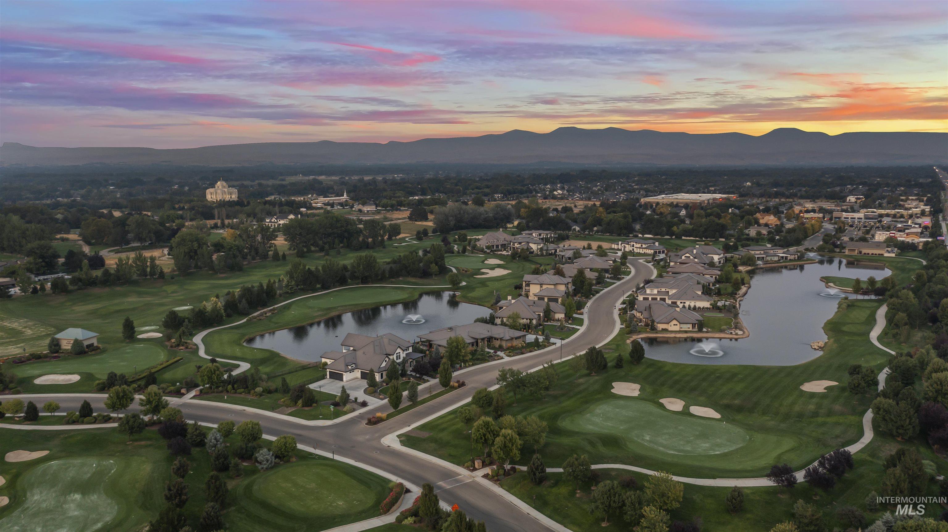 Aerial overview of property's location with a water and mountain view, a golf course, and nearby suburban area