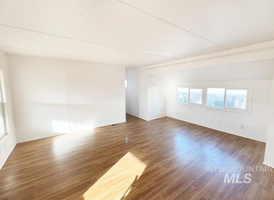 Empty room with plenty of natural light and wood finished floors