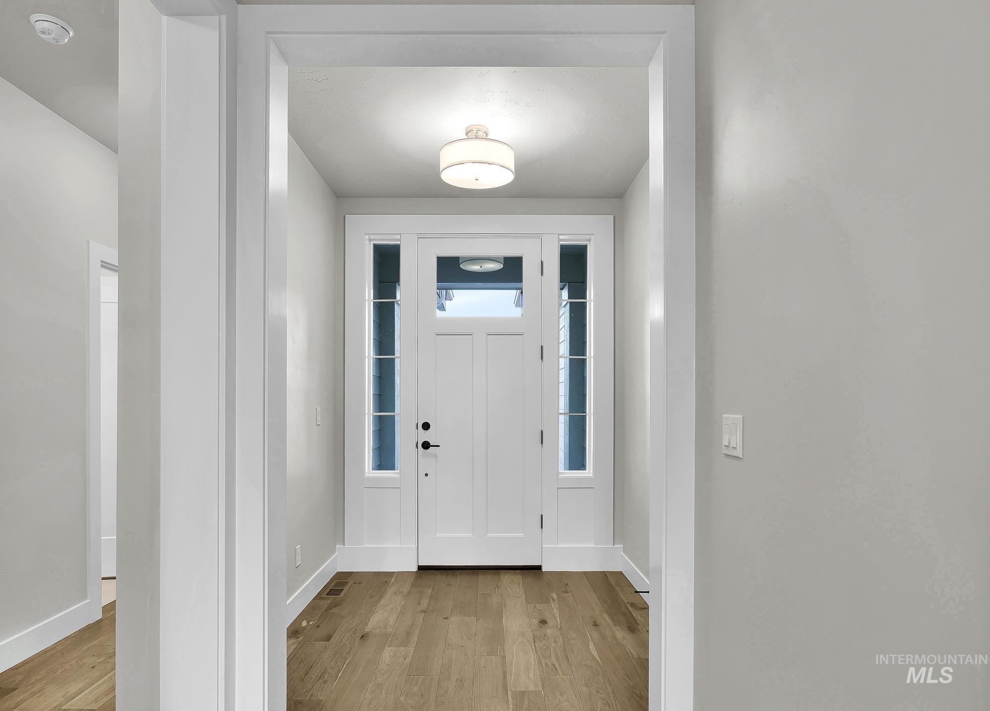Foyer with light wood-style floors and baseboards
