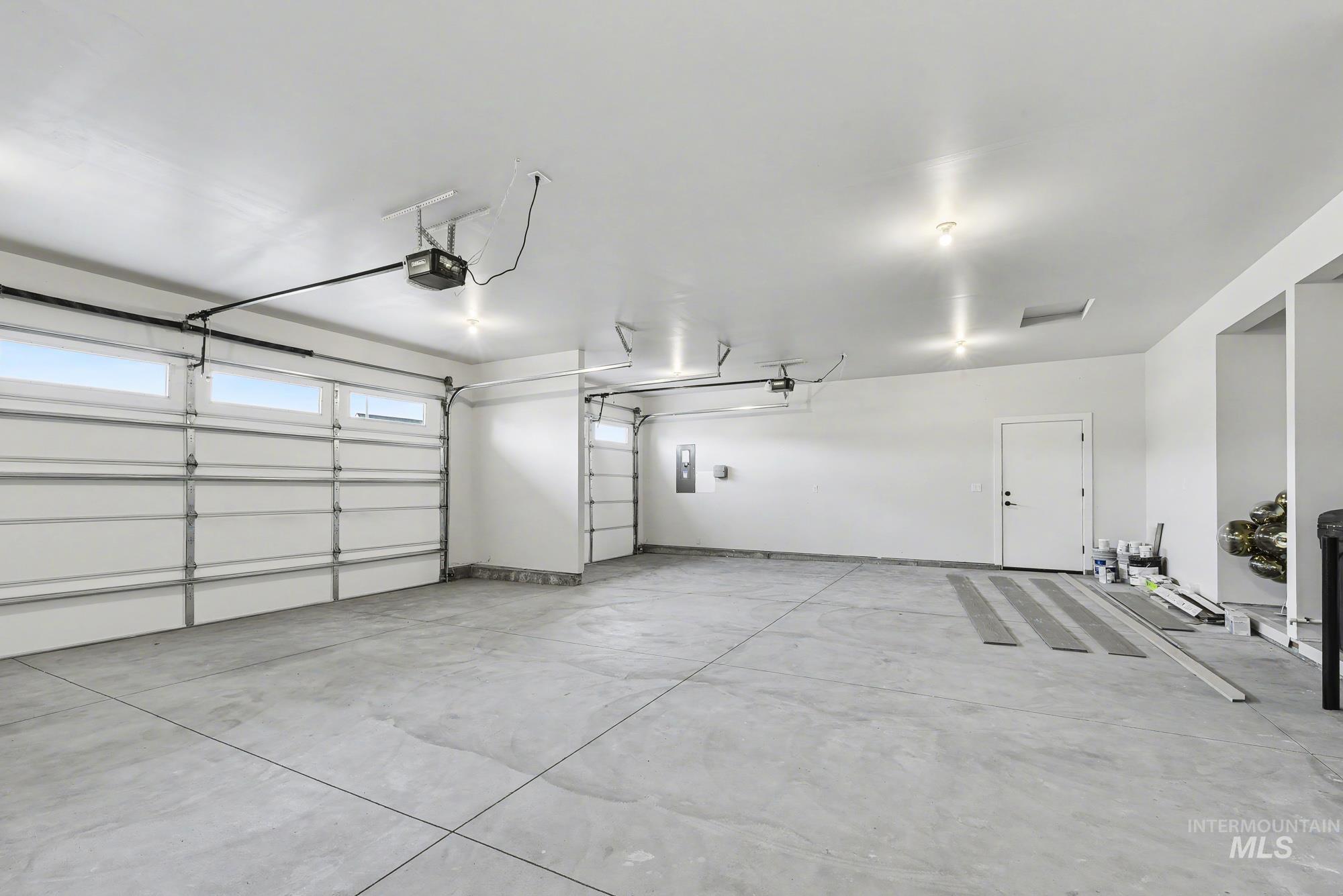 Garage with electric panel and a garage door opener