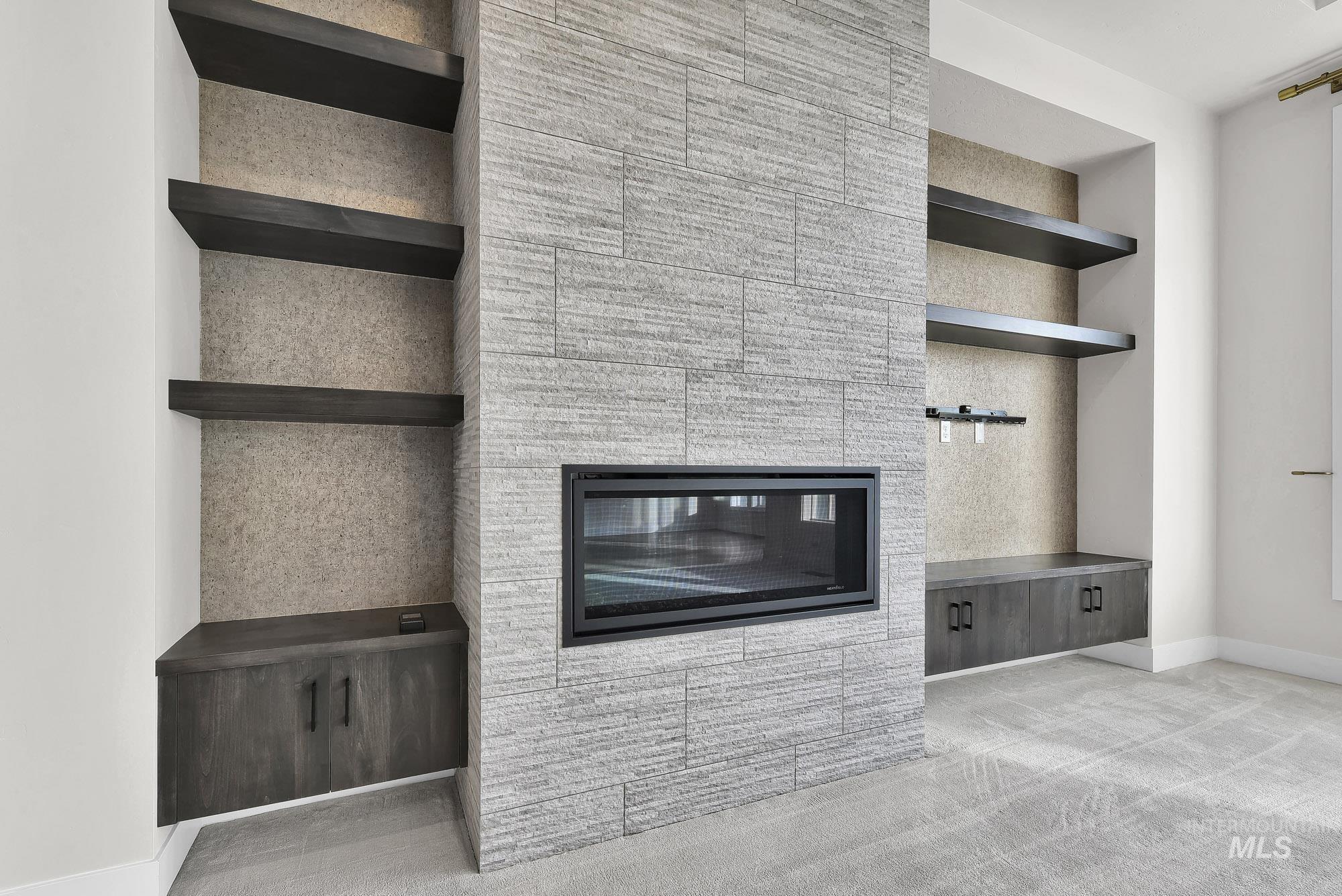 Detailed view of a large fireplace, built in features, and carpet floors