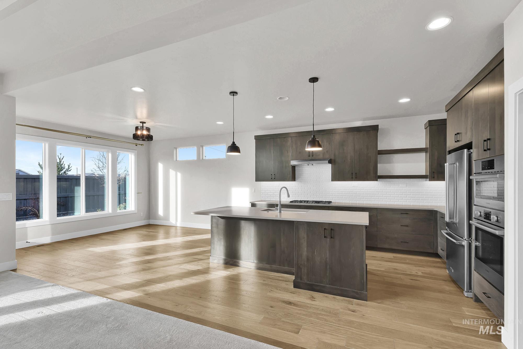 Kitchen featuring open shelves, dark brown cabinets, hanging light fixtures, modern cabinets, and open floor plan