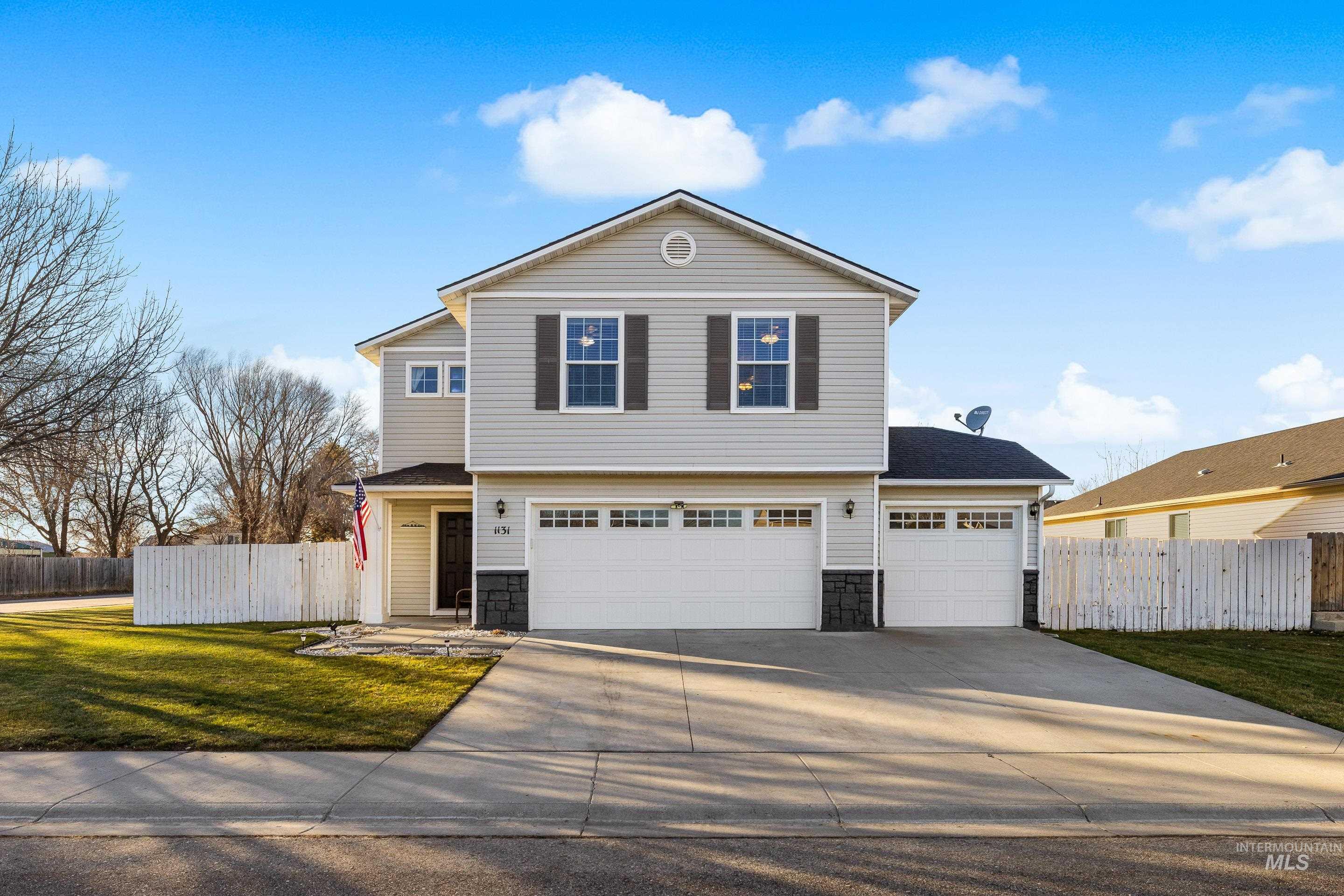 View of front of house with stone siding, concrete driveway, and a garage