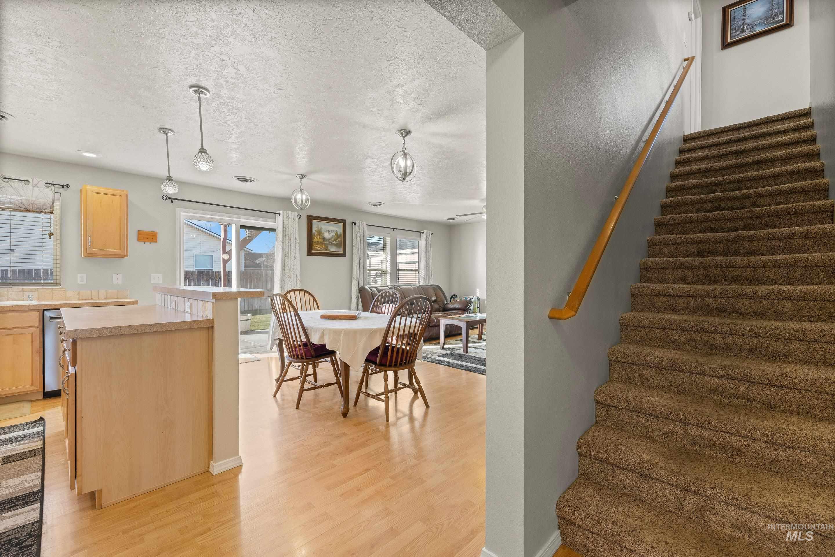 Stairs featuring a textured ceiling and wood finished floors