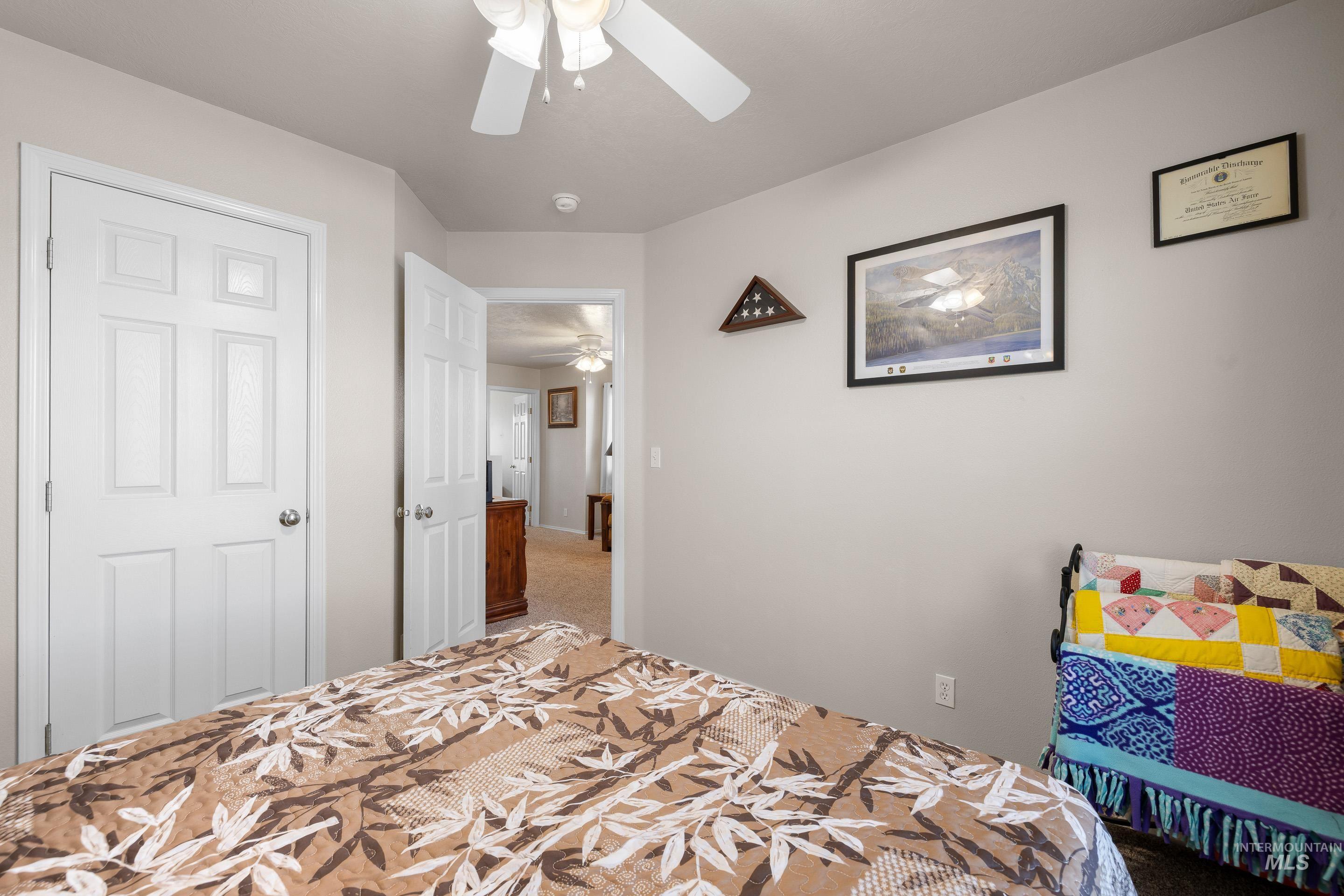 Bedroom featuring a ceiling fan and carpet floors