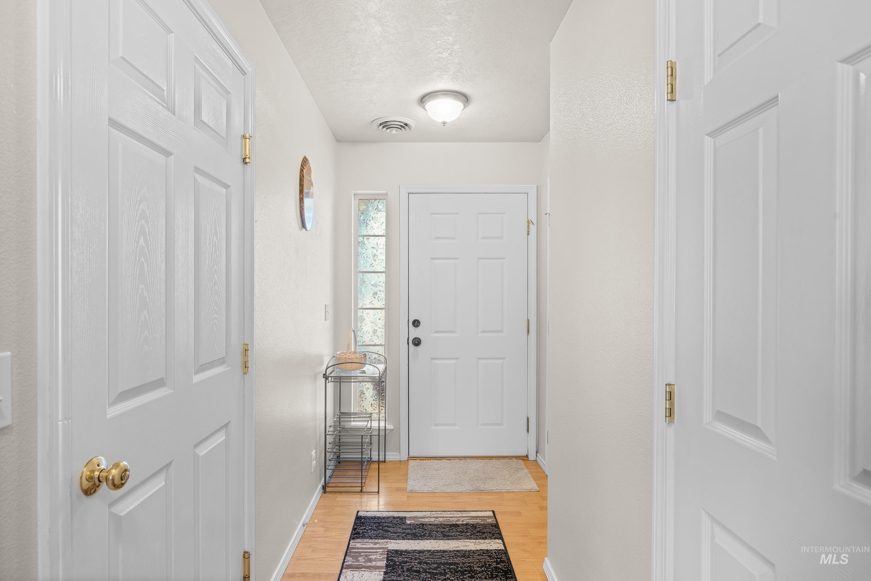 Foyer with light wood-style flooring and a textured ceiling