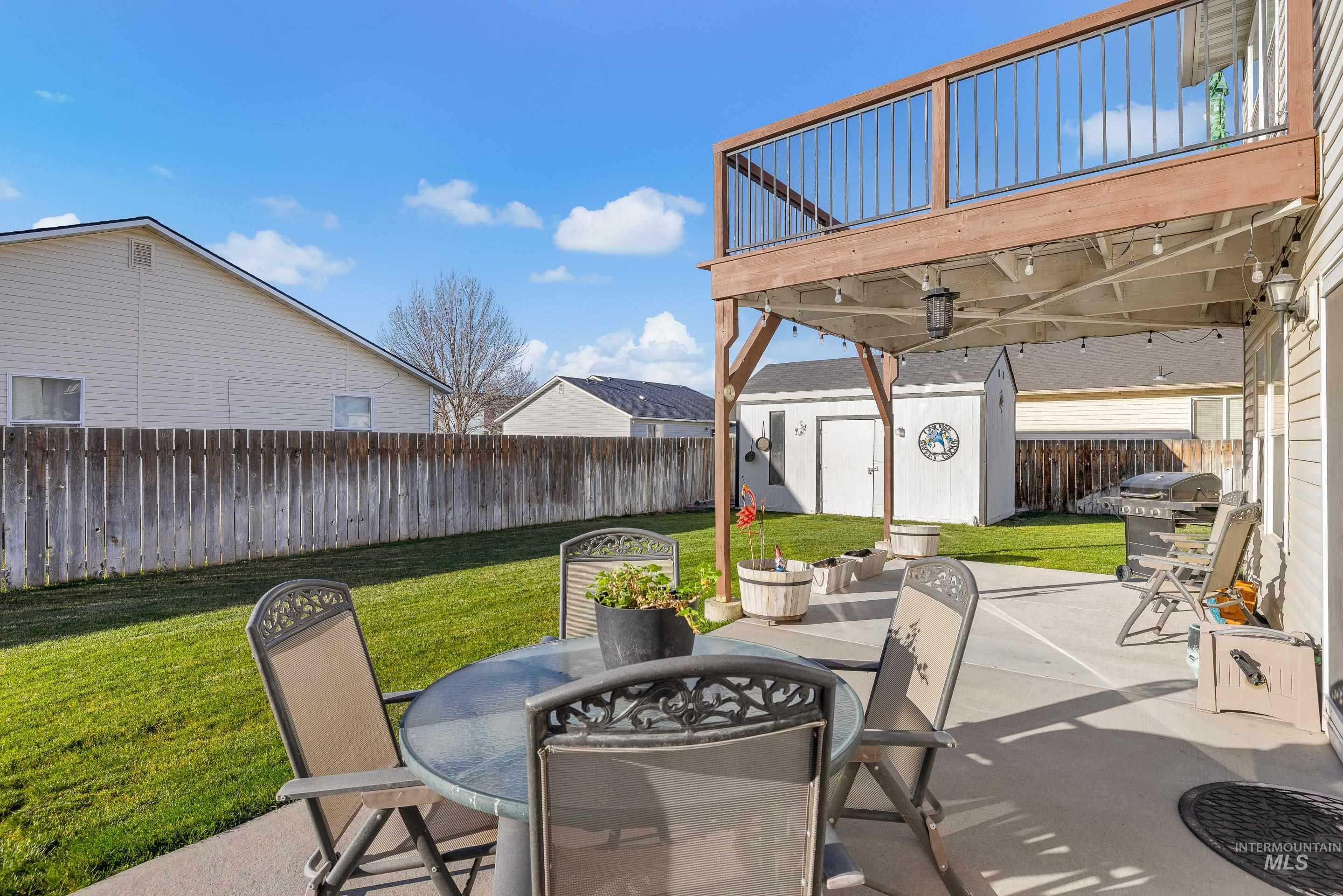 Fenced backyard with outdoor dining area, a patio area, a shed, and grilling area