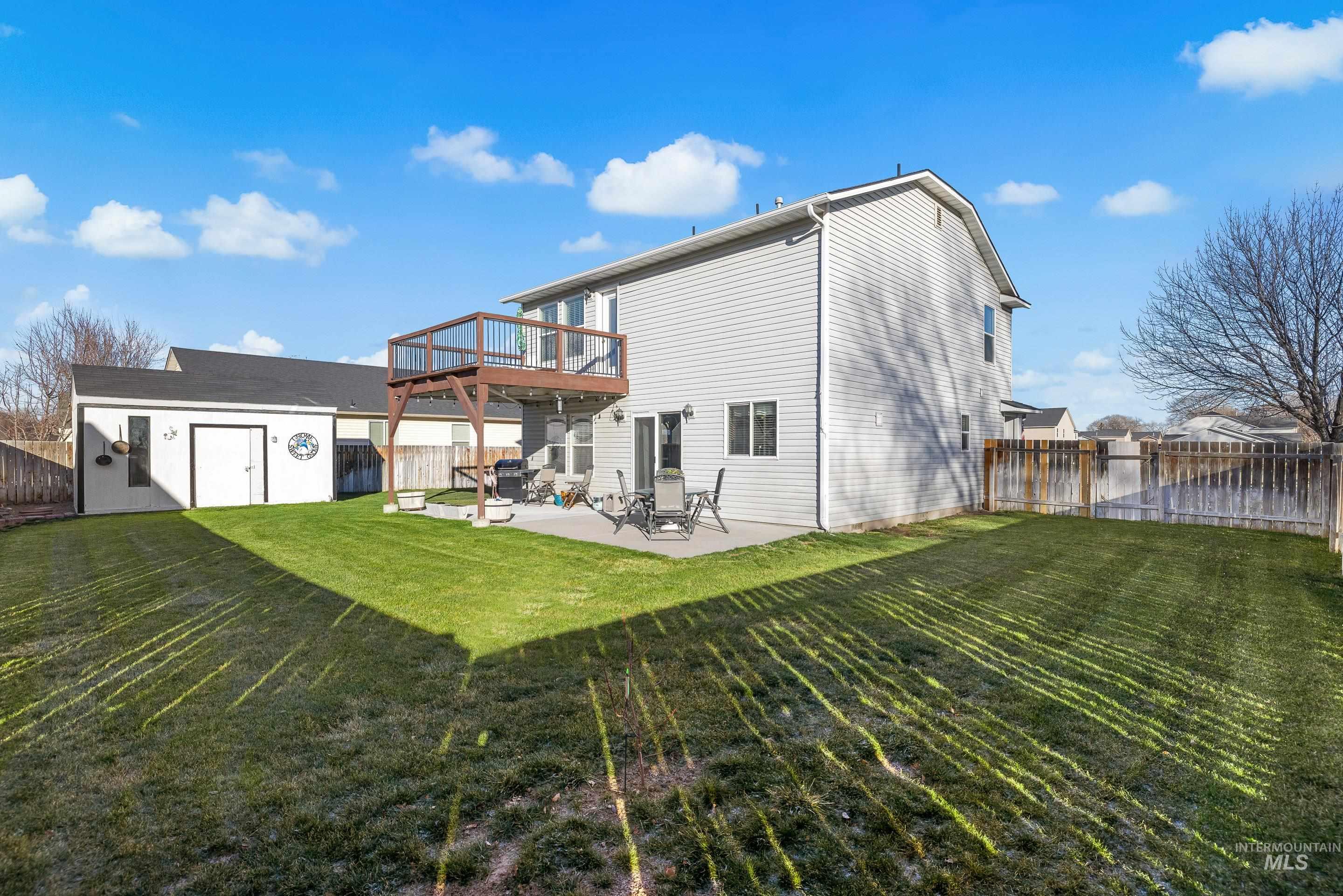Rear view of property featuring a fenced backyard, a patio, a storage shed, and a wooden deck