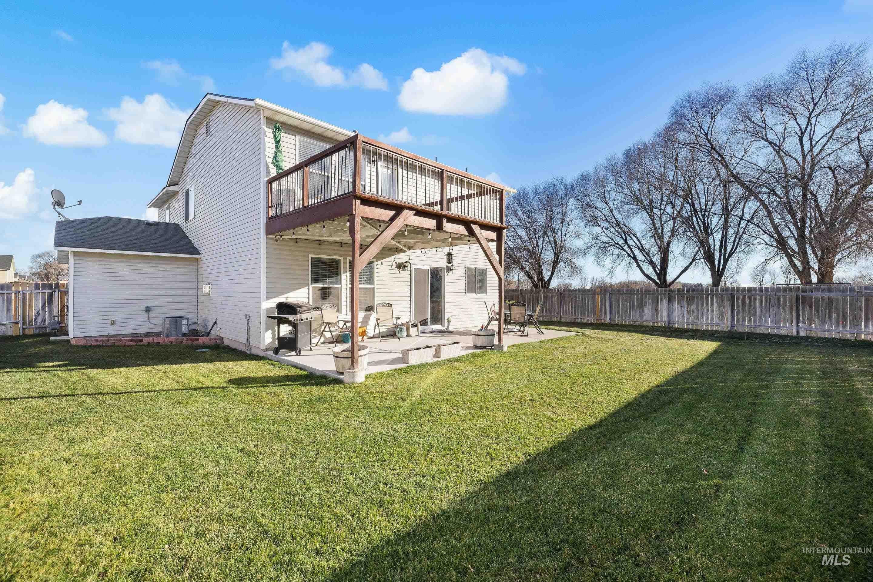 Back of house featuring a patio area, a fenced backyard, and a wooden deck