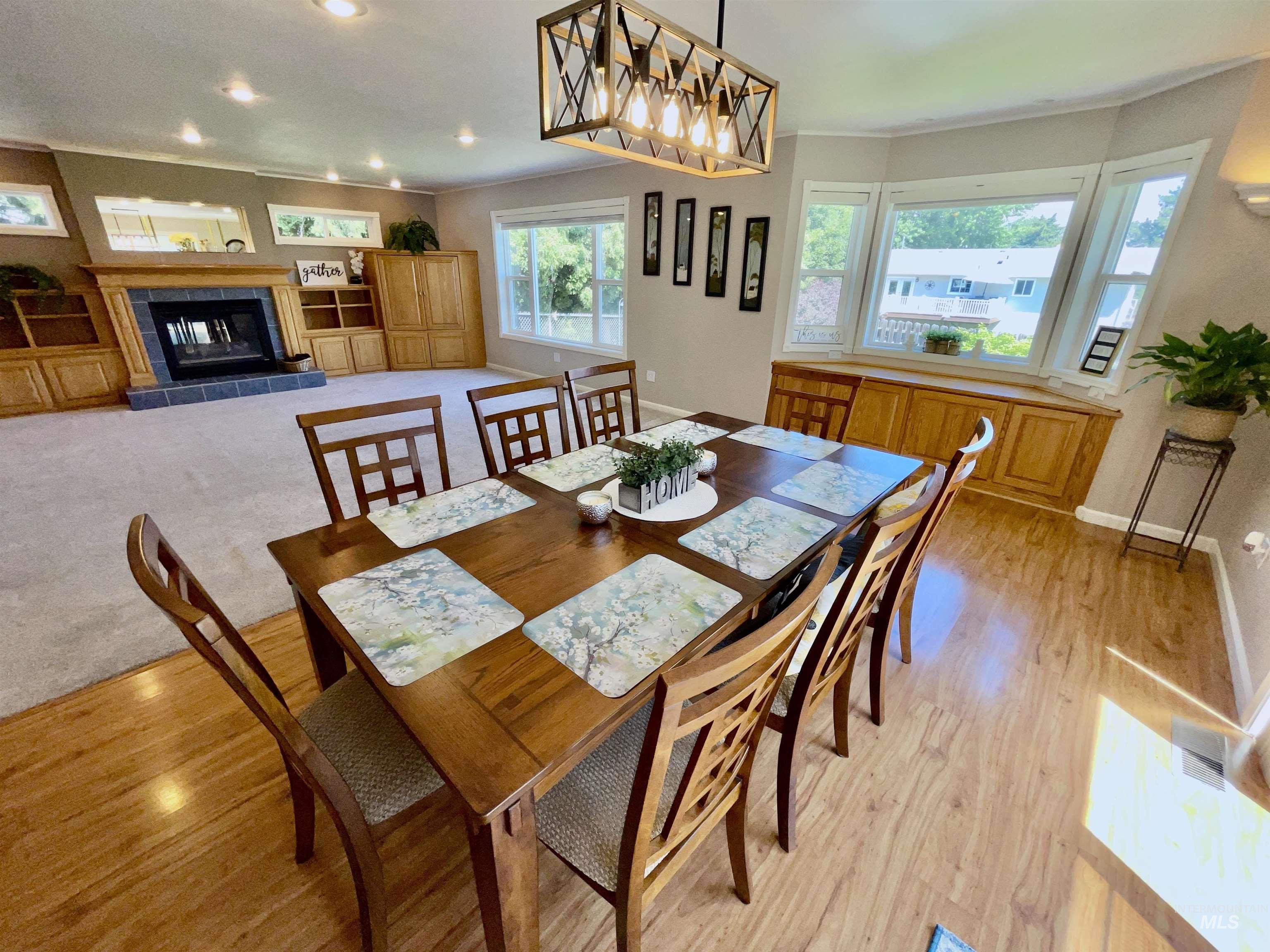 Dining space with crown molding, a tile fireplace, and recessed lighting