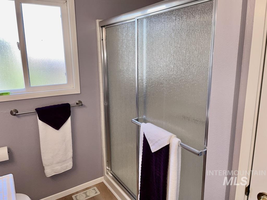 Full bath featuring a stall shower and baseboards