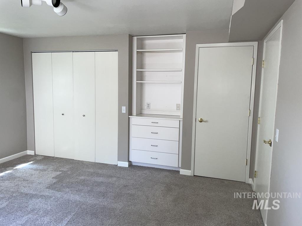 Unfurnished bedroom featuring a closet and dark colored carpet