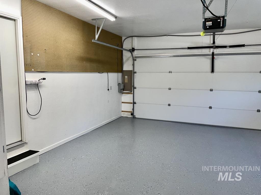 Garage featuring a garage door opener and electric panel