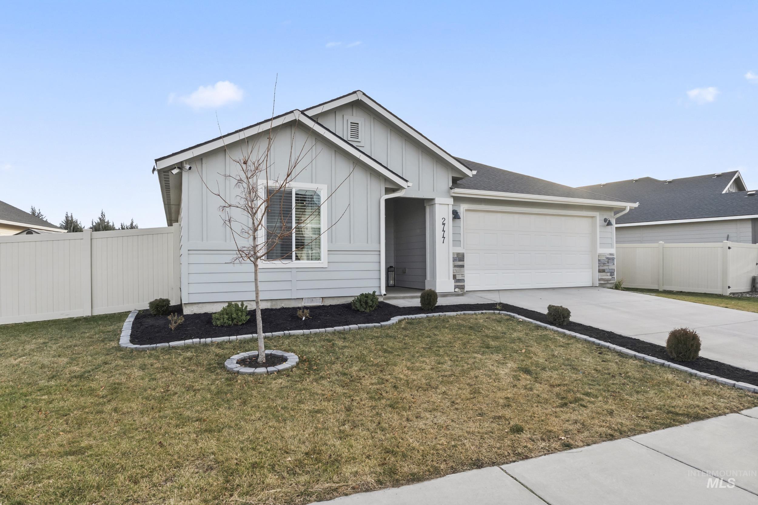 Ranch-style home with driveway, board and batten siding, and a garage
