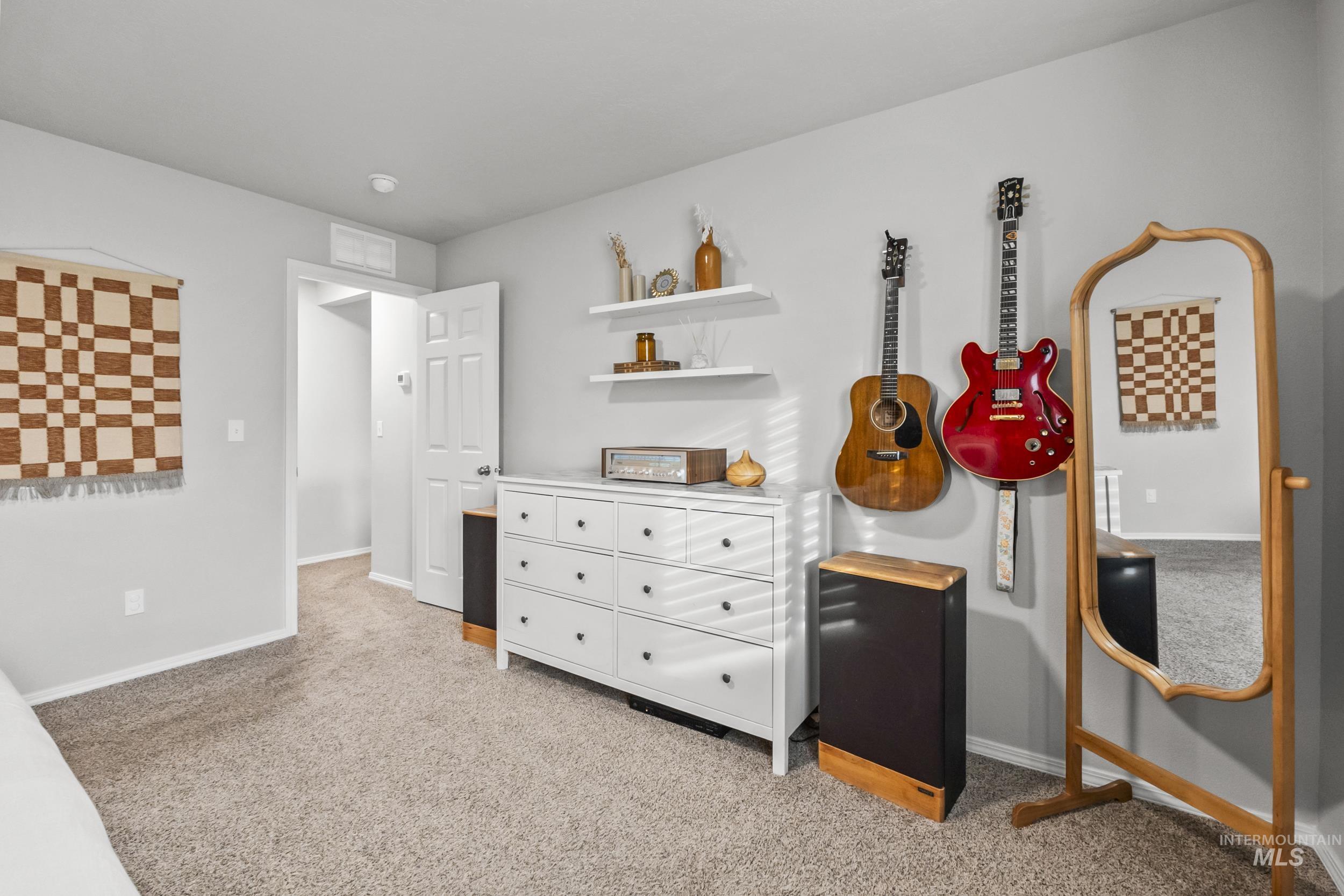 Bedroom featuring light carpet and baseboards