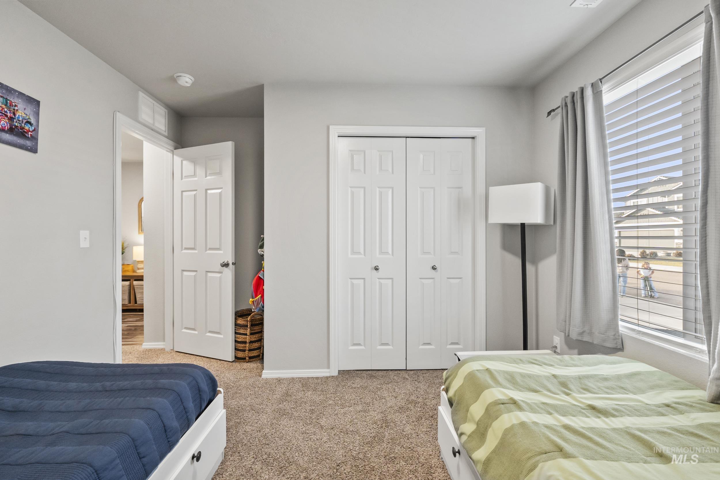 Bedroom featuring light colored carpet and a closet