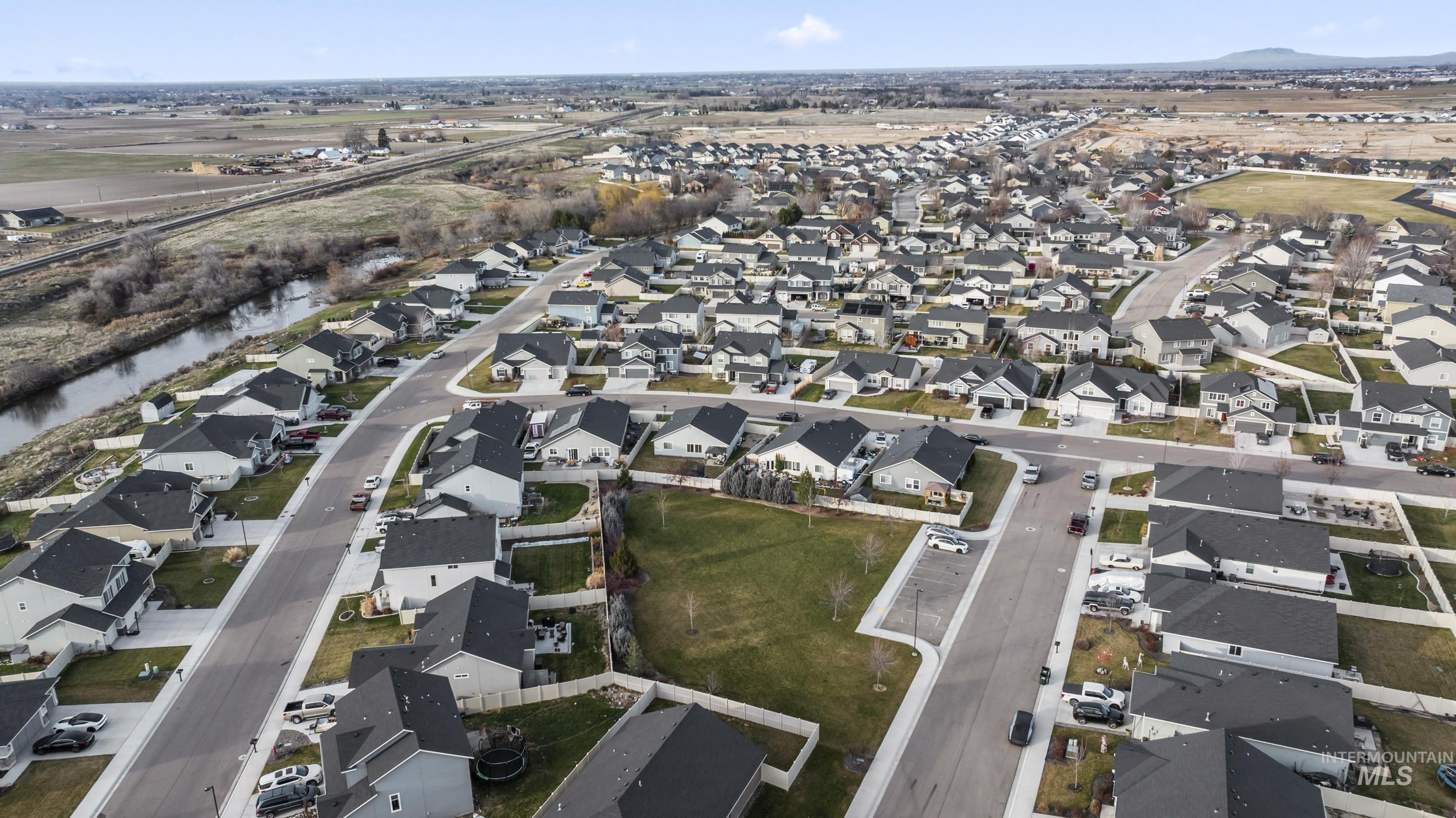 Aerial view of property and surrounding area featuring nearby suburban area