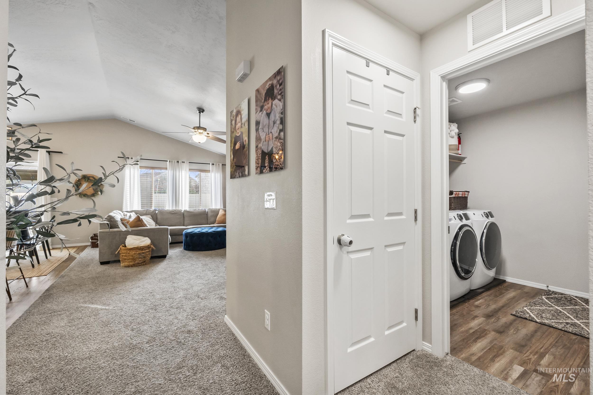Washroom with dark colored carpet, independent washer and dryer, lofted ceiling, and a ceiling fan