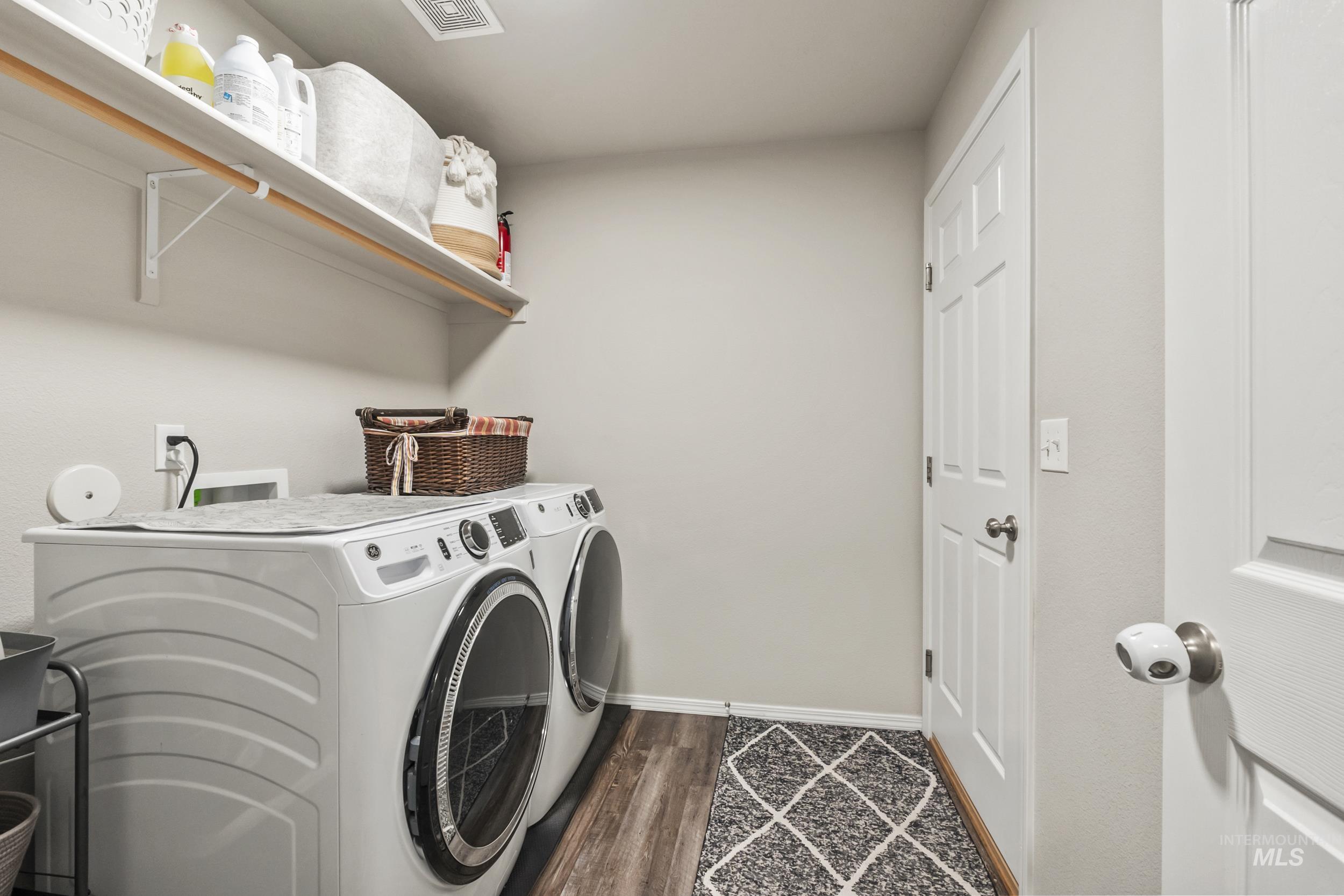 Laundry area with washing machine and dryer and dark wood-style floors