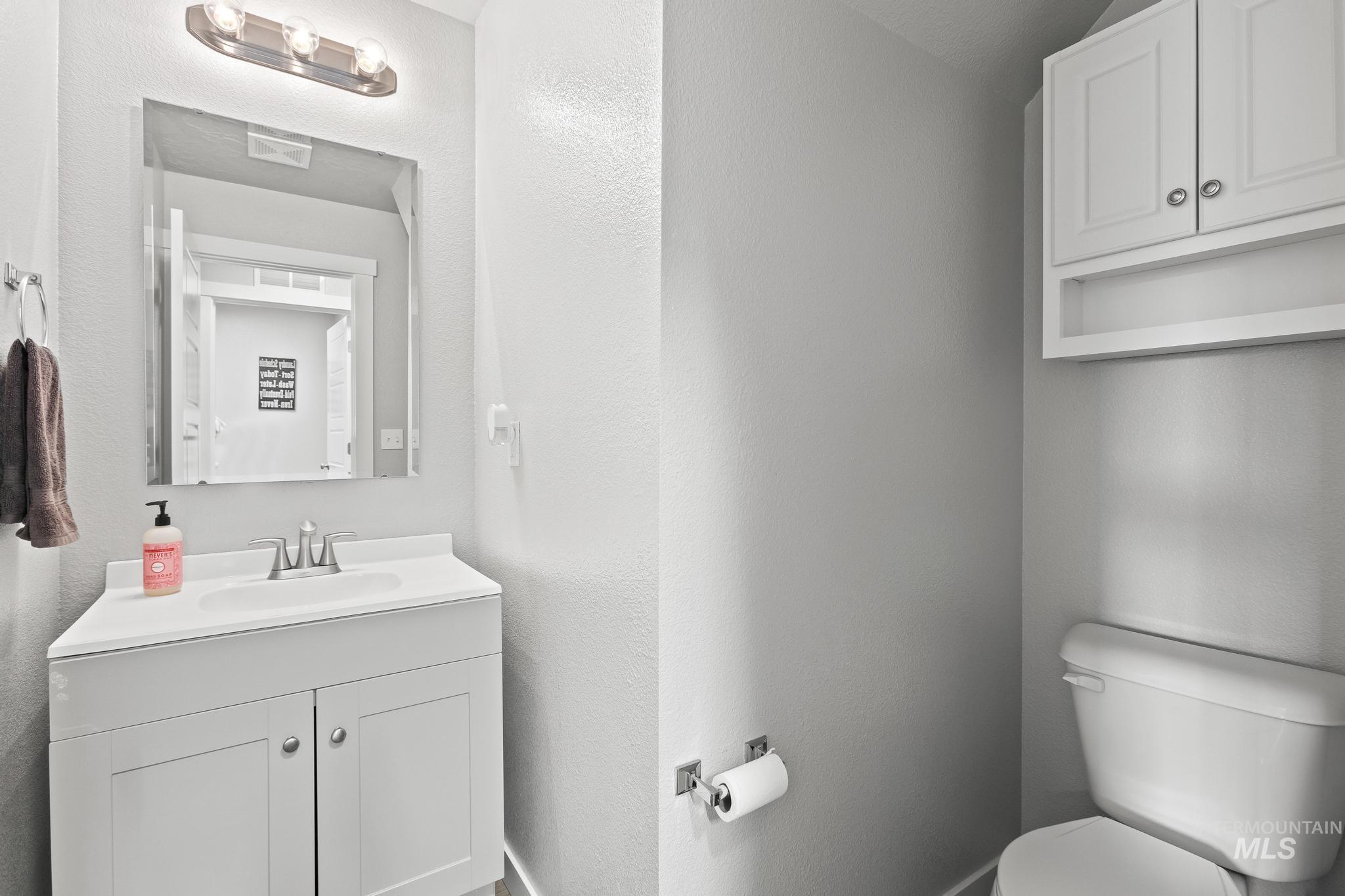 Half bathroom with vanity and a textured wall