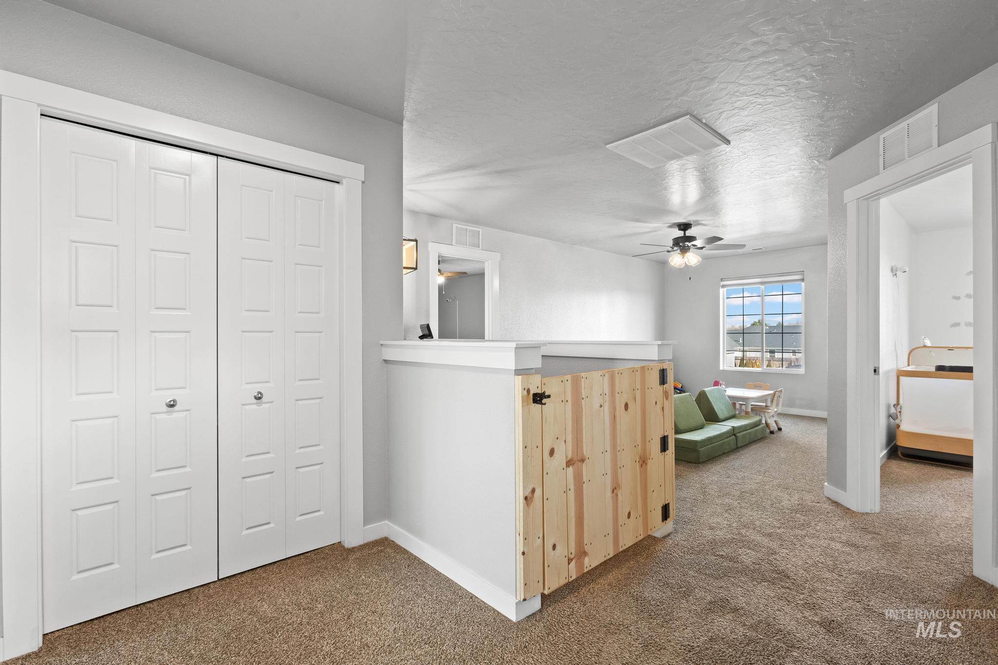 Hallway featuring dark carpet and a textured ceiling