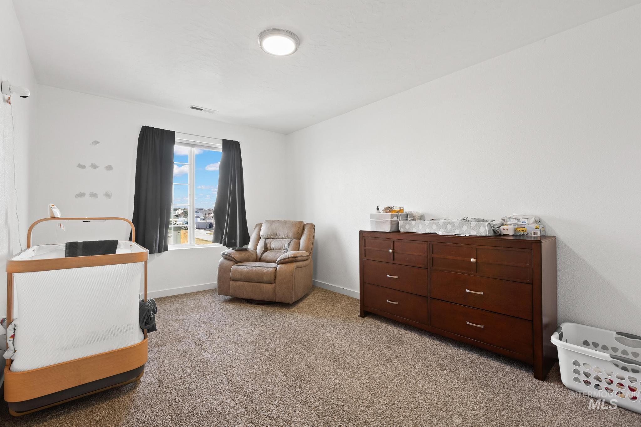 Bedroom with light colored carpet and baseboards