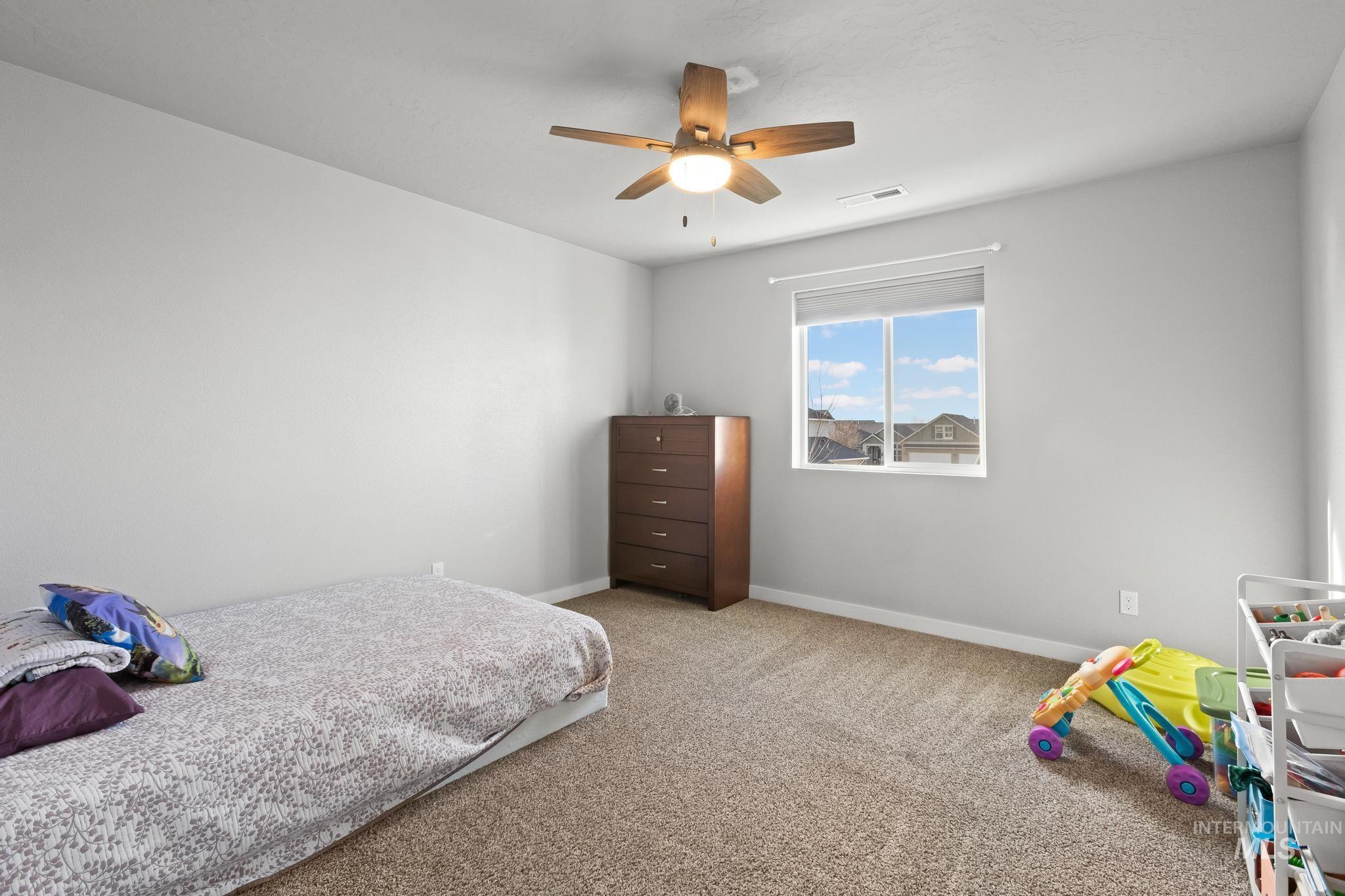 Bedroom with a ceiling fan and carpet flooring