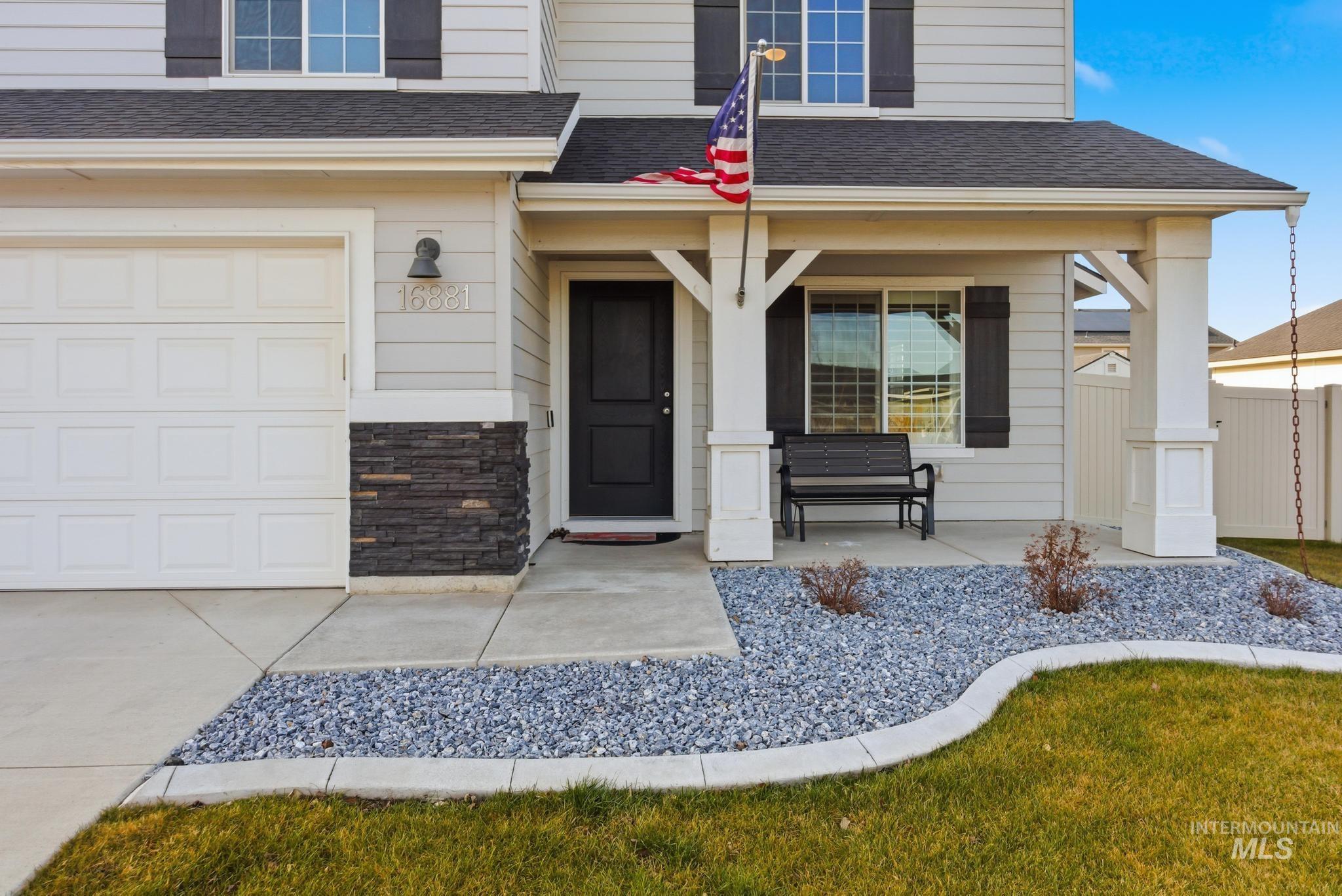 Entrance to property featuring a shingled roof, a porch, and stone siding