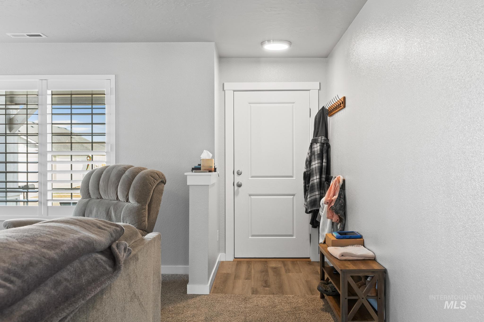 Foyer with a textured wall and baseboards