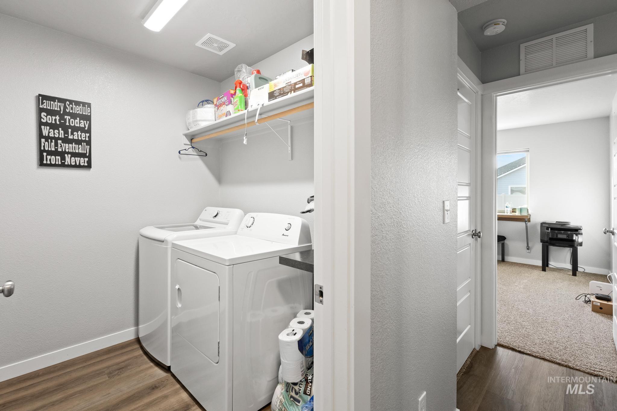 Laundry area with dark wood-type flooring and washer and clothes dryer