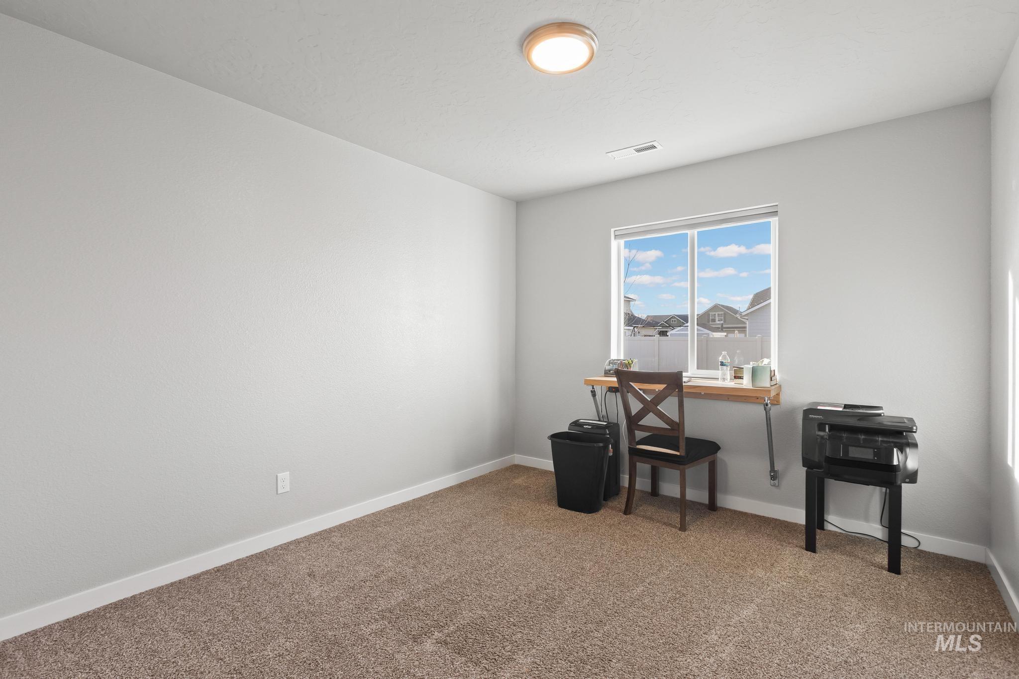 Home office with carpet floors and baseboards