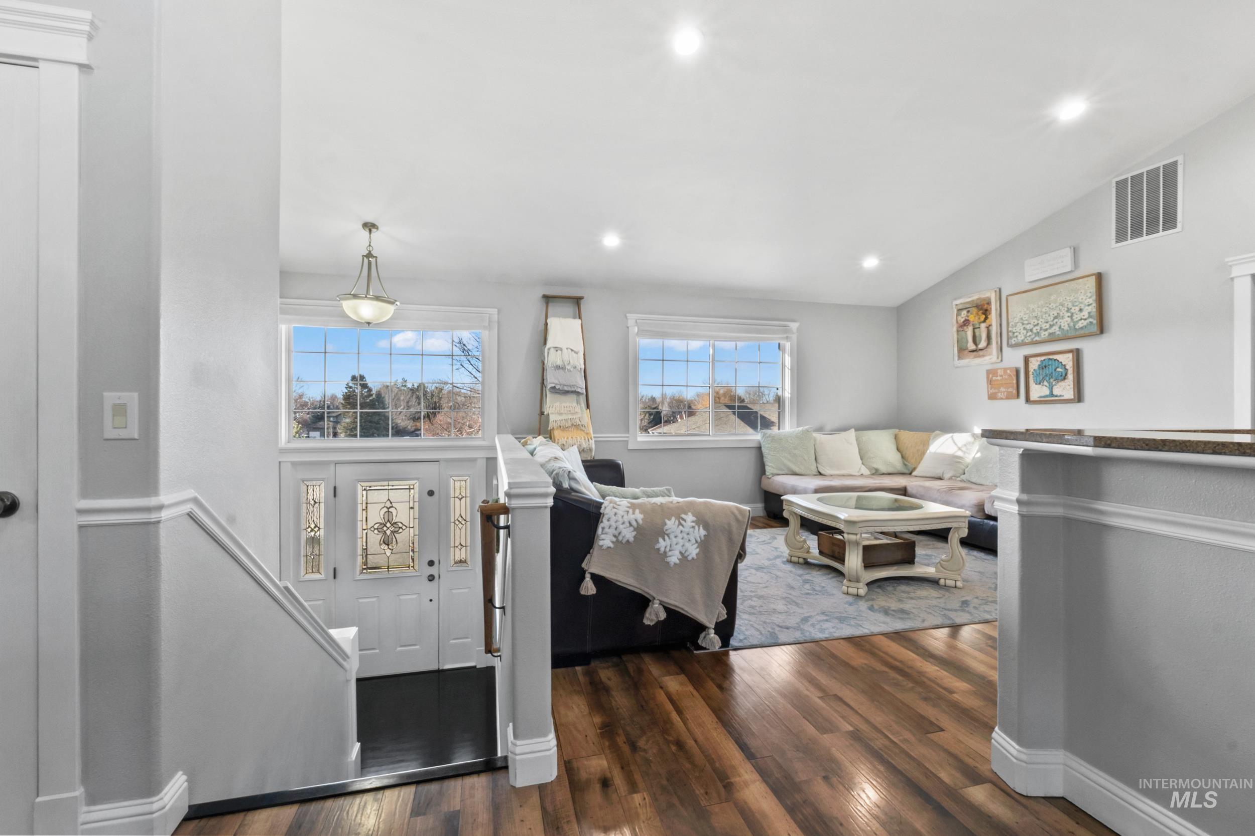 Living room with lofted ceiling, dark wood-type flooring, and recessed lighting