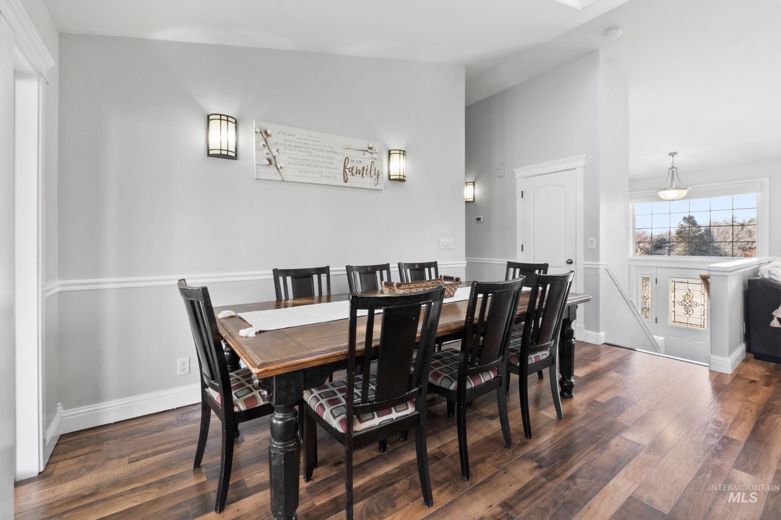 Dining space featuring dark wood-style flooring and baseboards