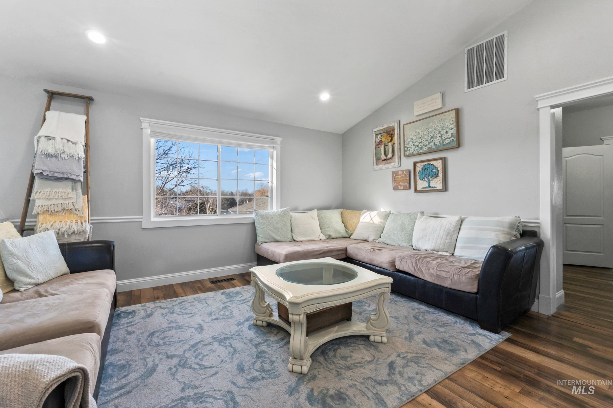 Living area with vaulted ceiling, dark wood finished floors, and recessed lighting